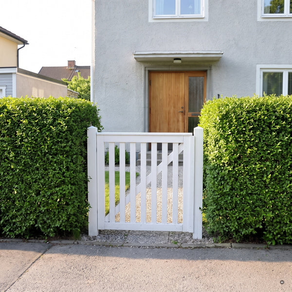 Geschnittene Ligusterhecke im Vorgarten mit weißer Gartenpforte vor dem Haus